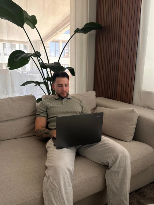 Severin arbeitet mit seinem Laptop auf dem Sofa